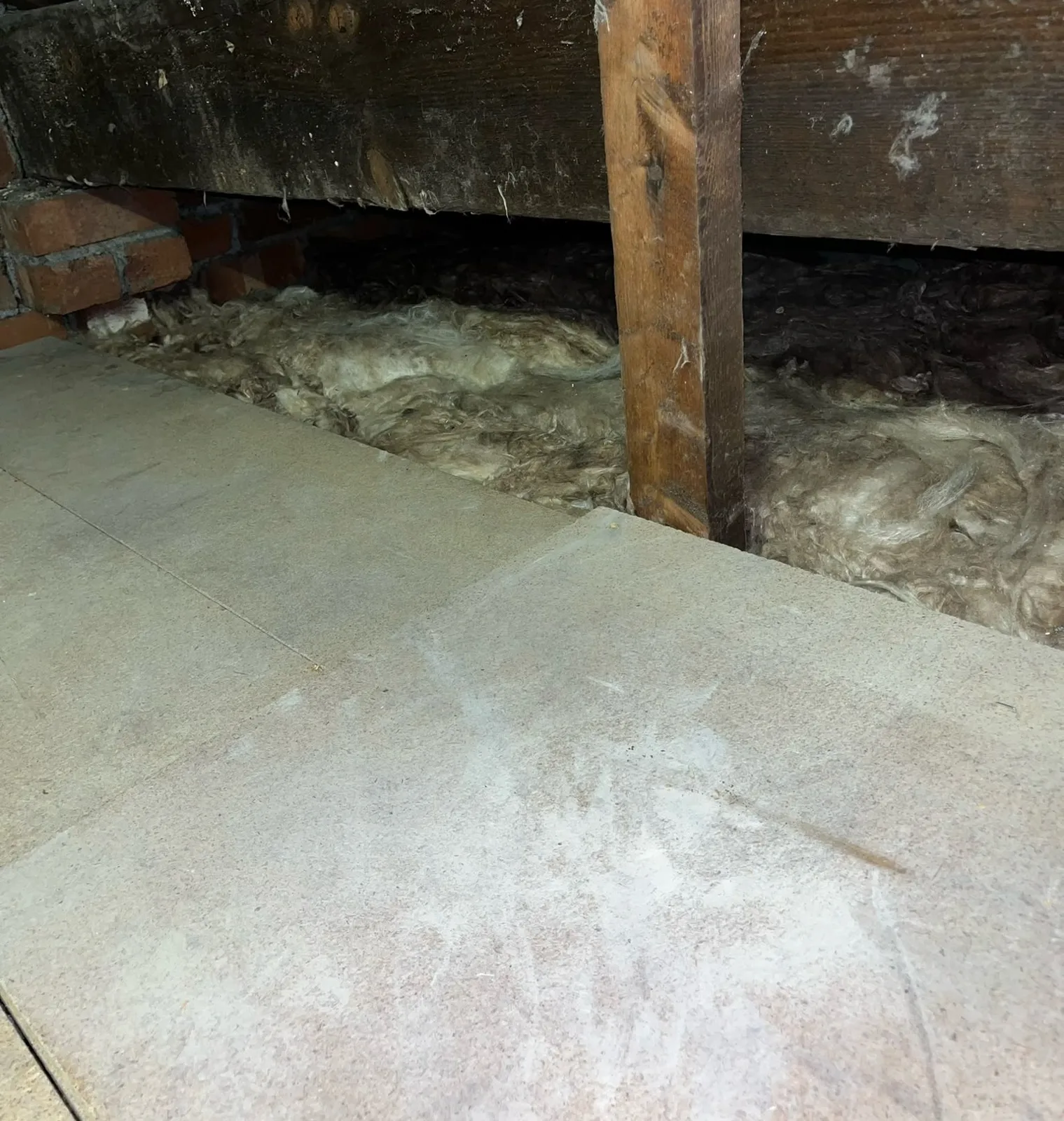 Reused loft boards and mineral wool insulation along the edge of the boarded area in a Kendal loft