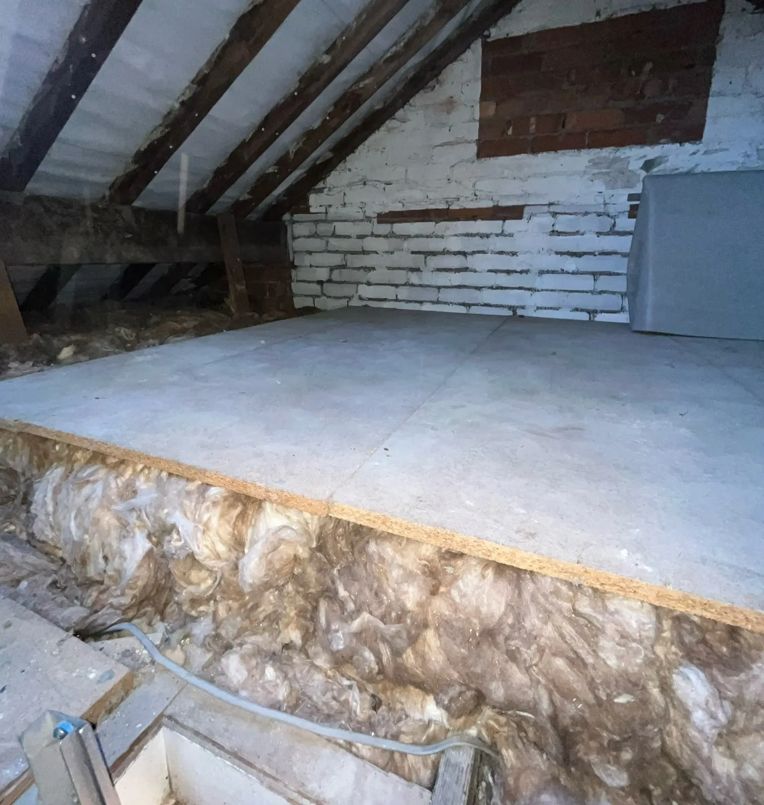 Finished raised loft boarding floor in Kendal with the full insulation depth showing along the edge