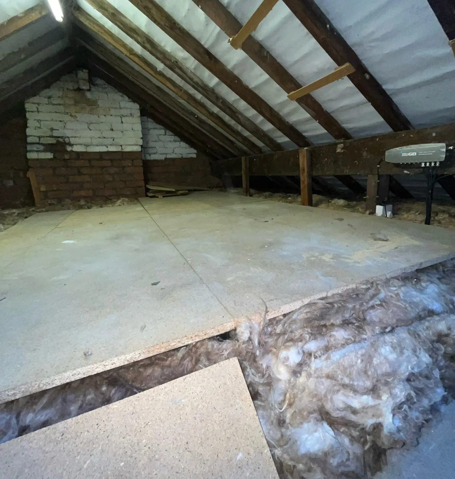 Raised loft boarding in a Kendal loft with 300mm of mineral wool insulation visible beneath the boards