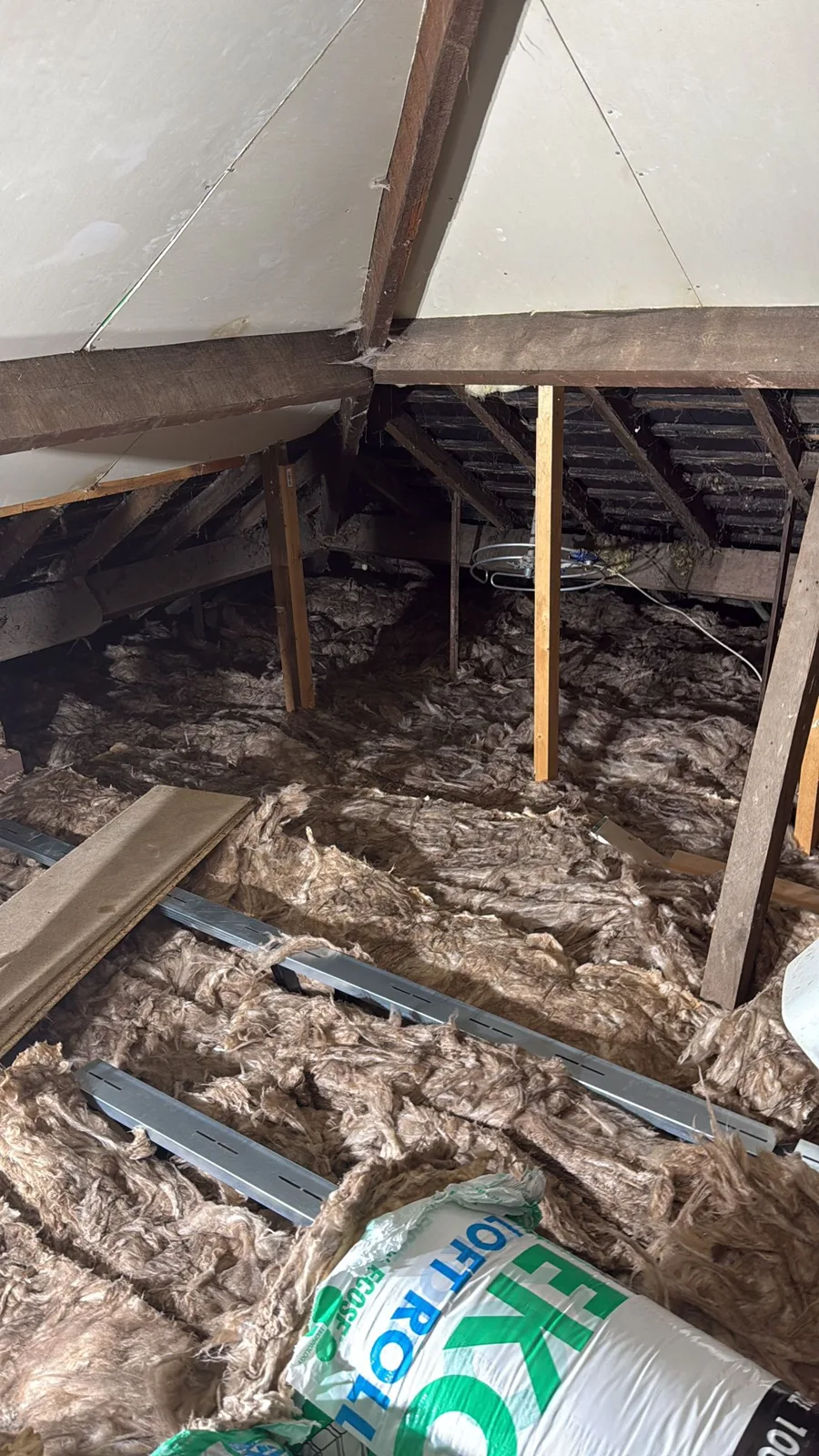 Knauf loft roll being laid between the joists during loft insulation in Aldridge