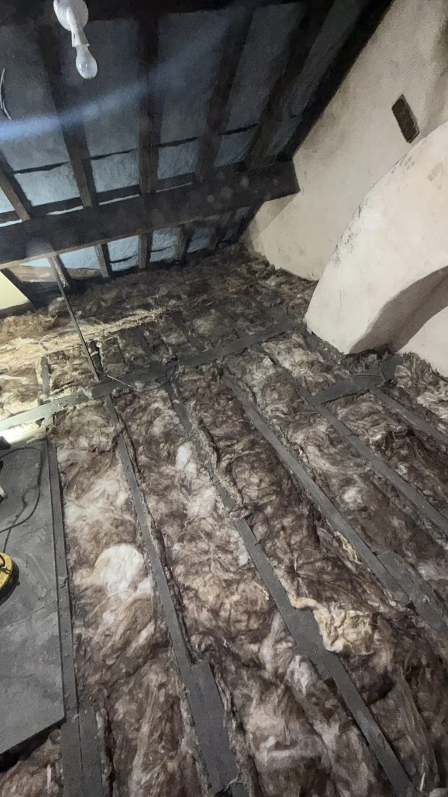 First layer of mineral wool loft insulation laid between the joists in a Chesterfield loft