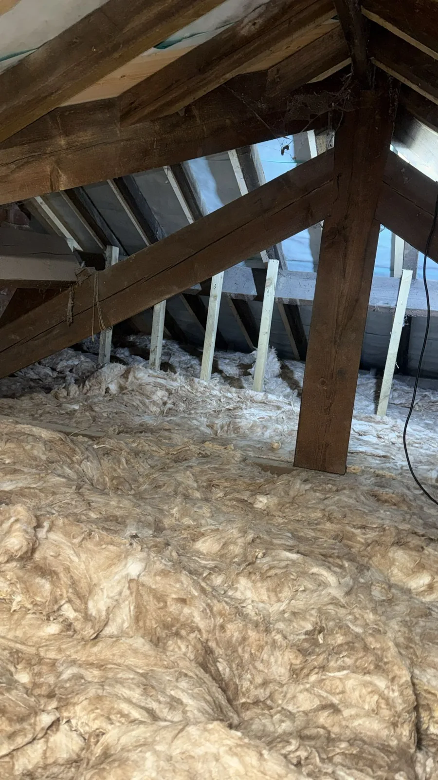 New 300mm mineral wool loft insulation laid across the joists of a Huddersfield loft