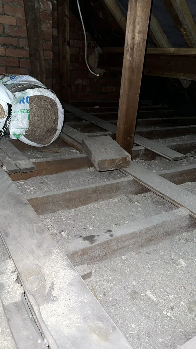 Bare loft joists in Leeds with new insulation rolls ready to go down