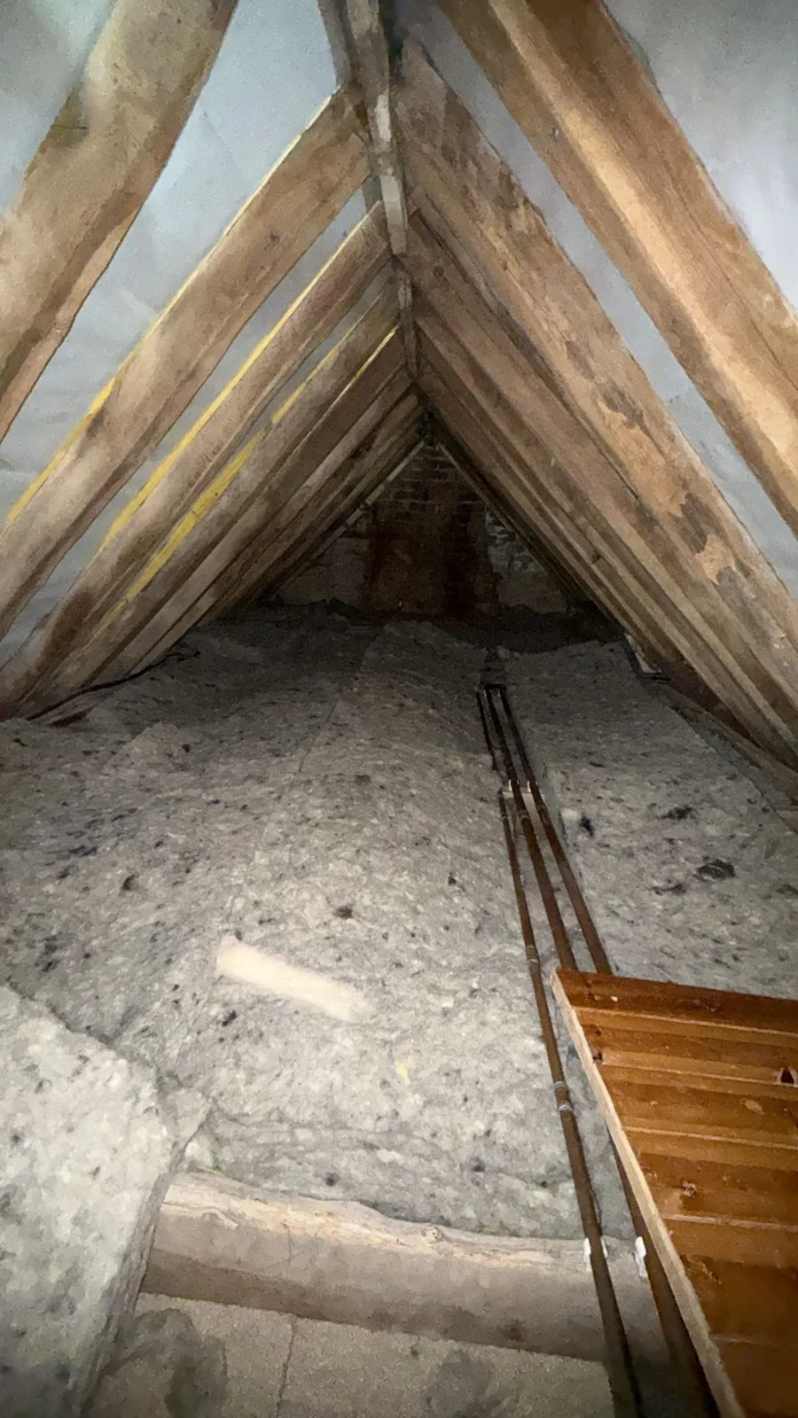 Sleaford area loft with new loft insulation across the floor and a boarded walkway beside the pipework