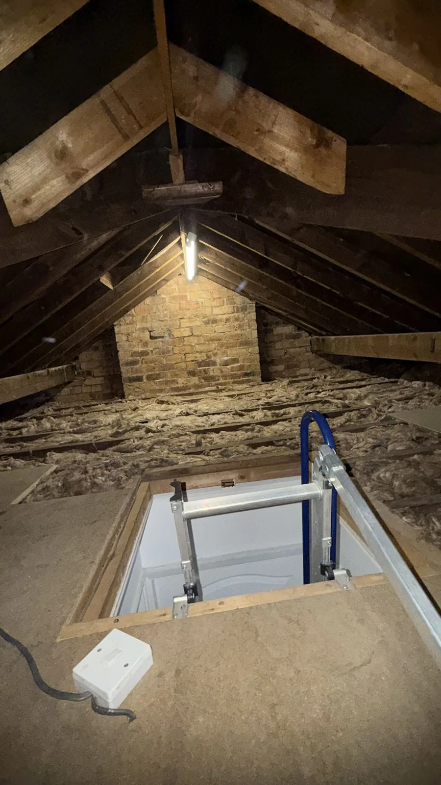 Old boarding around the loft hatch before loft insulation in Walsall