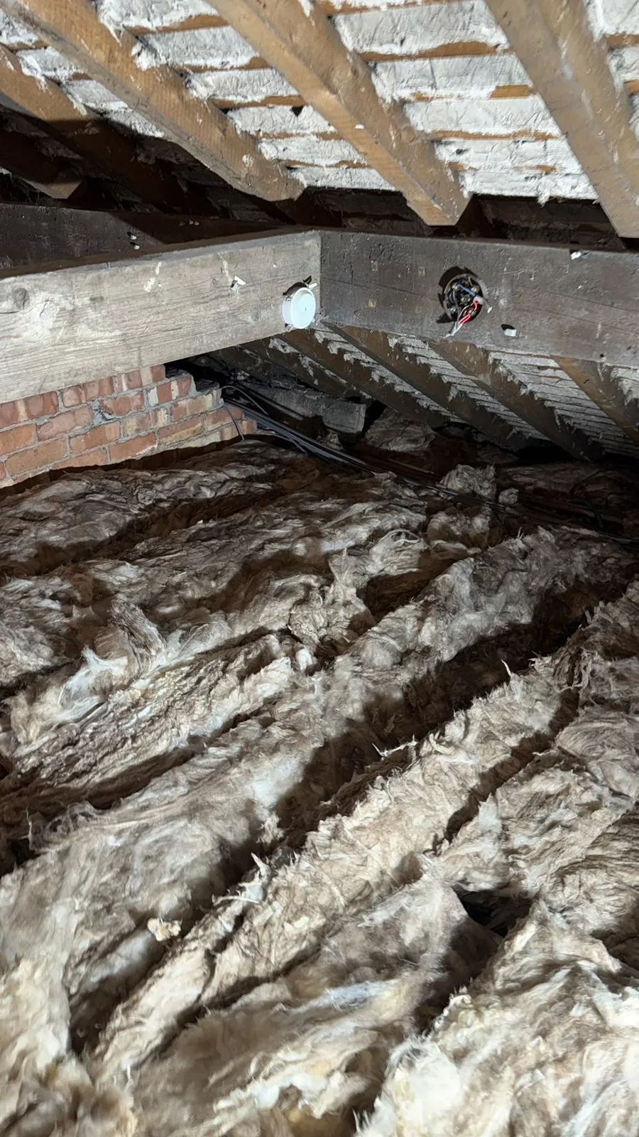 New mineral wool loft insulation laid in rows across the joists of a Warrington loft