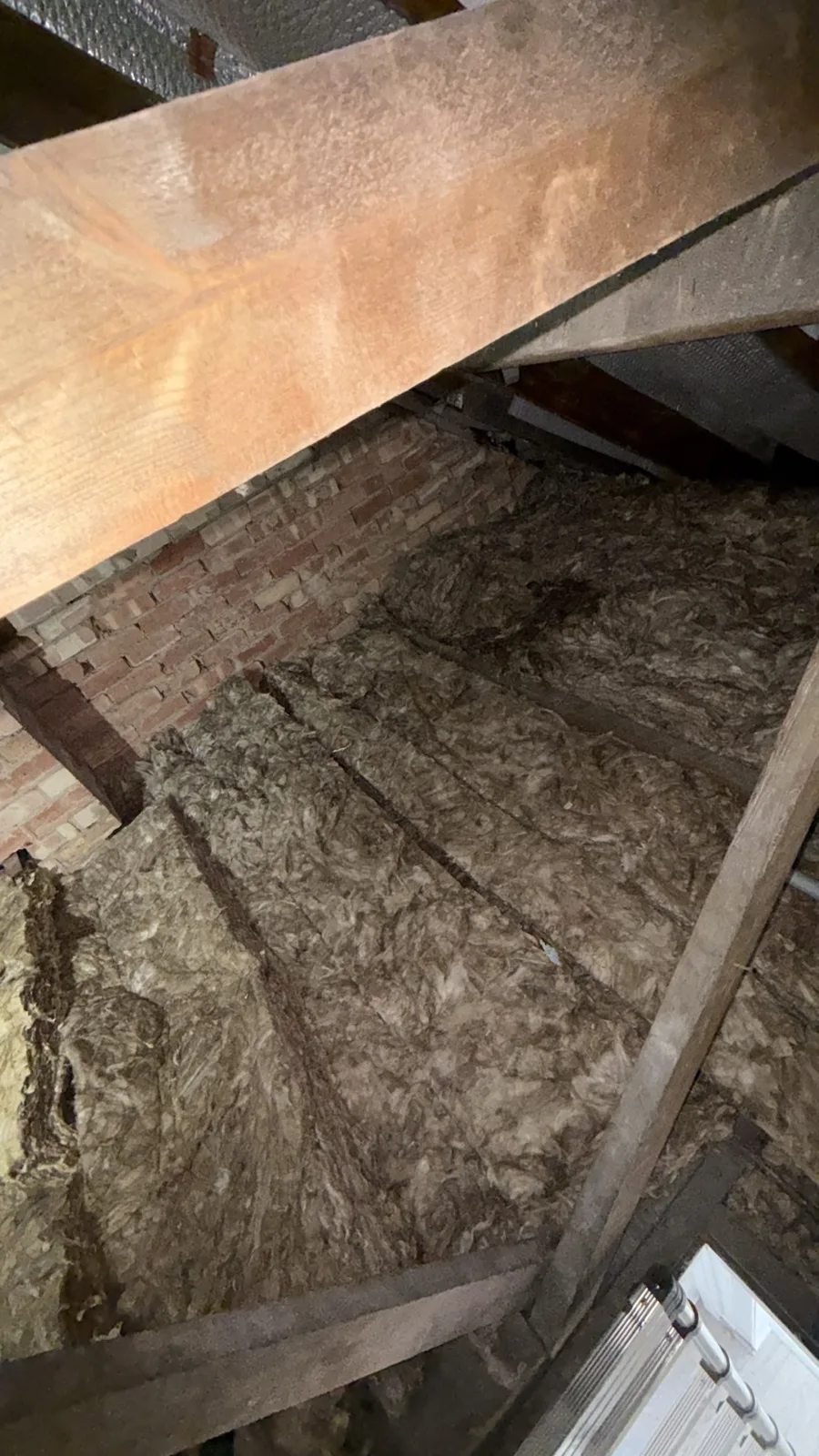 Finished loft insulation running up to the brick gable wall in a Worksop loft