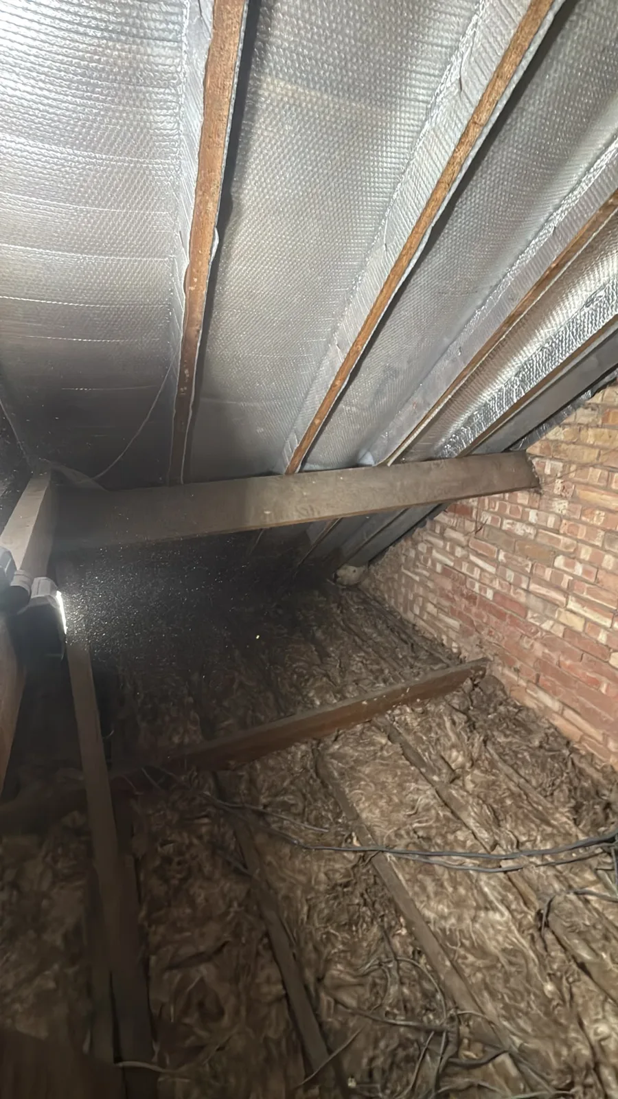 Worksop loft with old fibreglass insulation along the joists before loft insulation was replaced