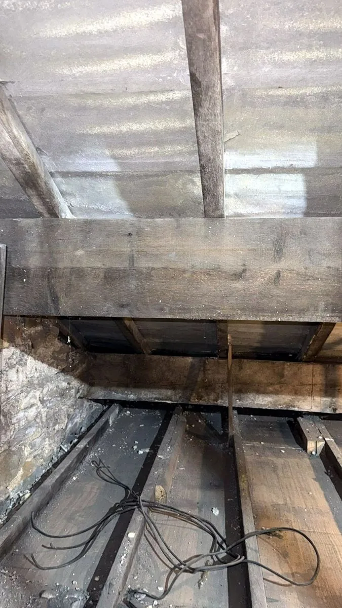 The same Burnley loft roof after spray foam removal, with the timbers and boards on show