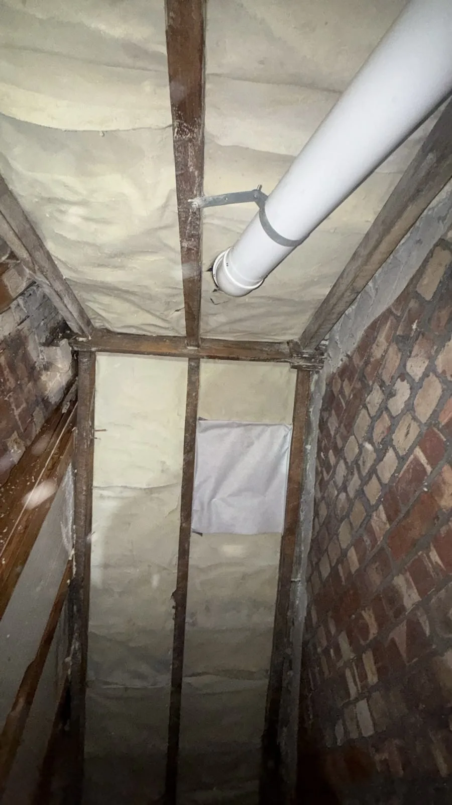 Narrow eaves loft in Oldham during spray foam removal, with rafters on show