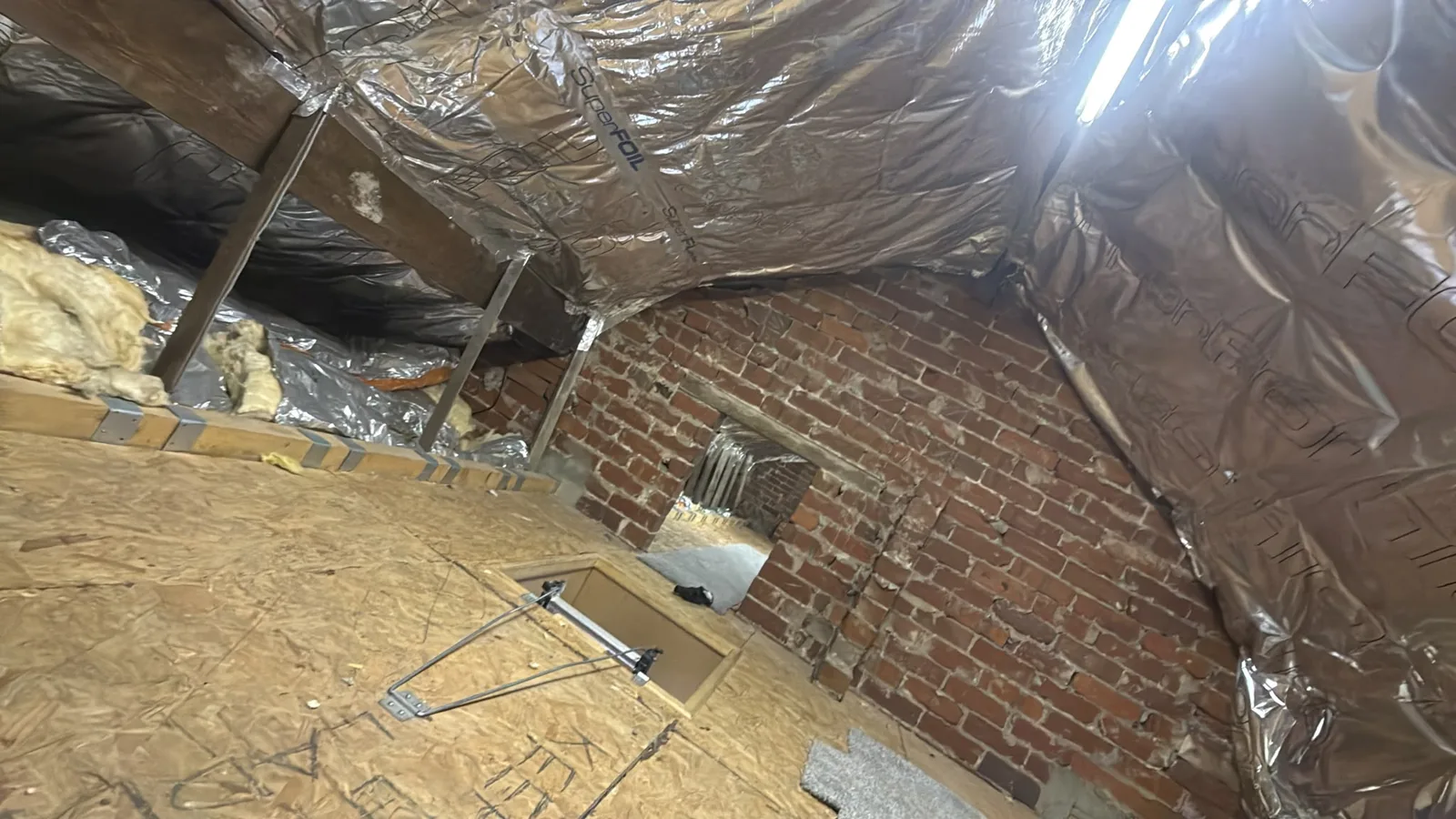 SuperFOIL multifoil insulation meeting the brick gable wall in a Blackburn loft