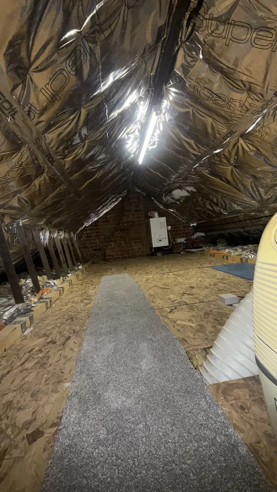 Loft near Blackburn with SuperFOIL insulation lining the rafters above a boarded floor and walkway
